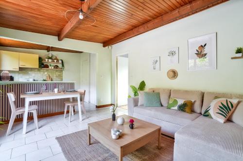 un salon avec un canapé et une table dans l'établissement Charmante maison indépendante avec terrasse verdoyante au calme absolu aux portes de Paris, à Houilles