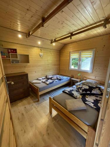 a room with two beds in a log cabin at Zielona Dolina Hoczew in Hoczew