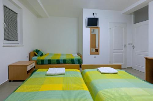 a room with two beds and a tv on the wall at Villa Miranda NG in Ohrid