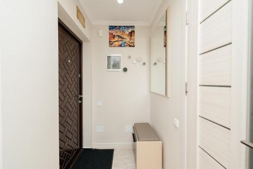 a hallway with white walls and a door and a bench at LuxRent in Chişinău