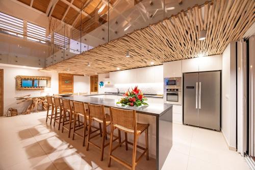 a kitchen with a large island with bar stools at Villa Tohora in Teavaro