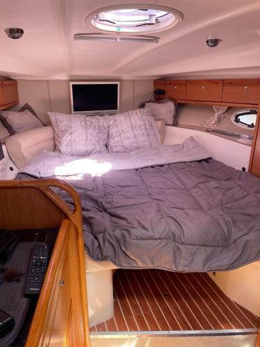 un lit au milieu d'un bateau dans l'établissement HEBERGEMENT INSOLITE SUR UN BATEAU À QUAI, à La Londe-les-Maures