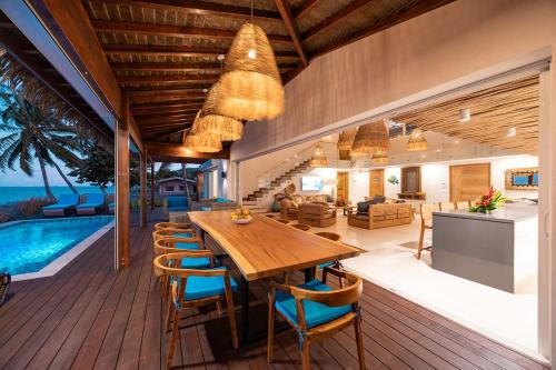 a dining room and living room with a table and chairs at Villa Tohora in Teavaro