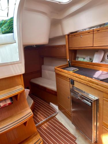 une petite cuisine avec des placards en bois et une cuisinière dans l'établissement HEBERGEMENT INSOLITE SUR UN BATEAU À QUAI, à La Londe-les-Maures