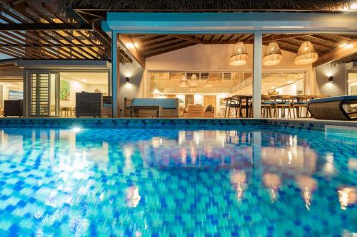 a large swimming pool with blue water in a building at Villa Tohora in Teavaro