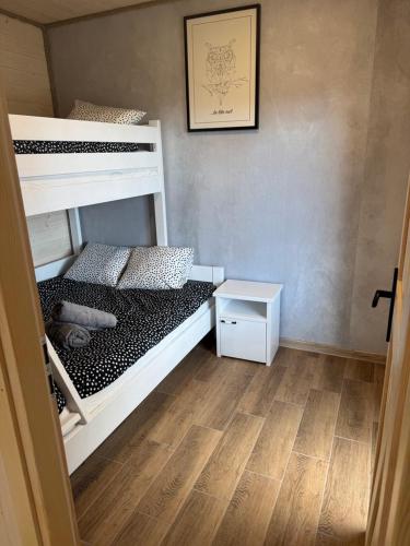 a bedroom with two bunk beds and a wooden floor at H&Z Radawa Zosia in Radawa