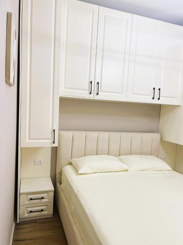 een slaapkamer met een bed en witte kasten bij A&E Seaside Apartment in Golem