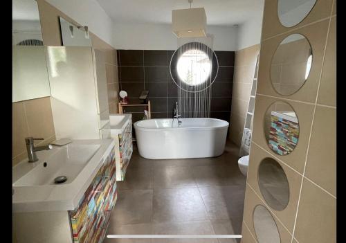 une salle de bain avec une baignoire, un lavabo et des toilettes dans l'établissement Villa avec piscine - mer Méditerranée sud de la France, à Torreilles