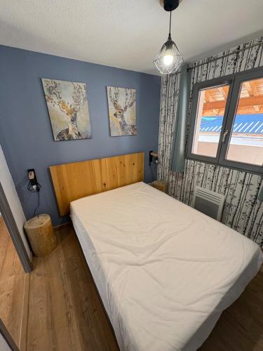 une chambre avec un grand lit blanc avec une fenêtre dans l'établissement Joue du Loup Apartement 6 personnes, à Saint-Étienne-en-Dévoluy