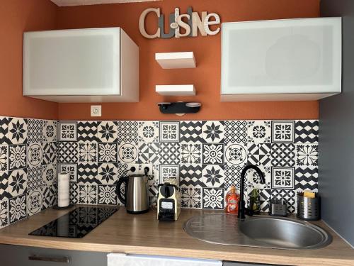 - une cuisine avec du carrelage noir et blanc sur le mur dans l'établissement Joue du Loup Apartement 6 personnes, à Saint-Étienne-en-Dévoluy