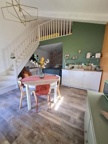 a kitchen and dining room with a table and stairs at Dépendance entre CAEN et la mer in Lasson