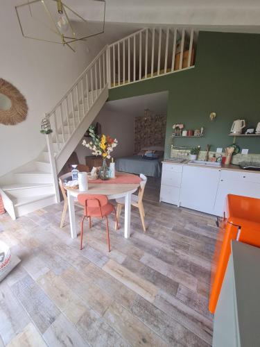 une cuisine et une salle à manger avec une table et un escalier dans l'établissement Dépendance entre CAEN et la mer, à Lasson