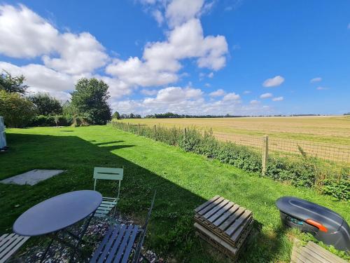 a picnic table and chairs in a field of grass at Dépendance entre CAEN et la mer in Lasson