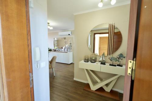 een badkamer met een wastafel en een spiegel bij Madalena Sunset by Mill Escapes in Madalena do Mar