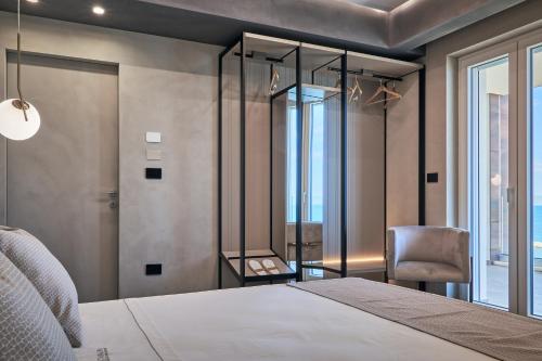 a bedroom with a bed and a chair and a window at THALORA - Luxury Apartments in Bari