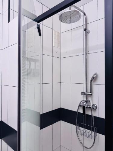 La salle de bains est pourvue d'une douche et de carrelage noir et blanc. dans l'établissement LE CARRAS - Proche de aéroport , Plage à pied - Promenade des anglais, à Nice