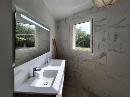 une salle de bain blanche avec un lavabo et un miroir dans l'établissement Villa 8 personnes, piscine, au calme, à Grasse