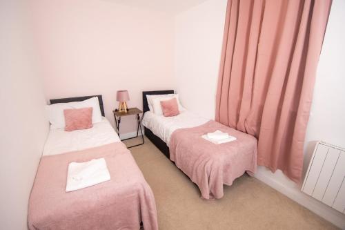 two twin beds in a room with pink sheets at Newly Renovated Sanctuary for 4 in Tacket Street, Ipswich in Ipswich