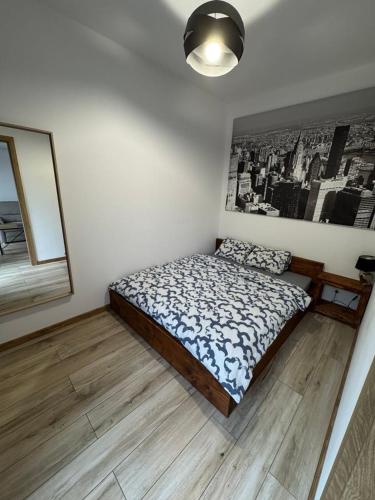 a bedroom with a bed and a picture on the wall at Apartament Jarosław in Jarosław