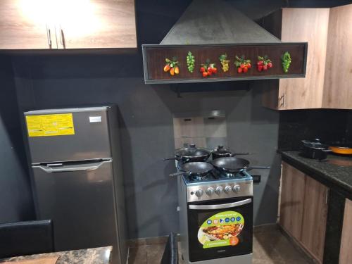una cocina con estufa y refrigerador en Alquileres El Ángel, en San Salvador