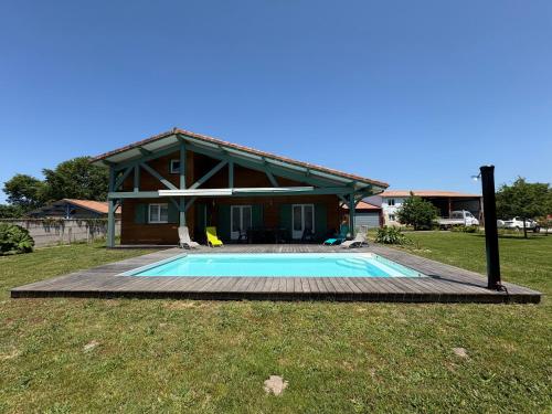 a house with a swimming pool in the yard at Villa landaise à 9km de l'Océan in Saint-Julien-en-Born