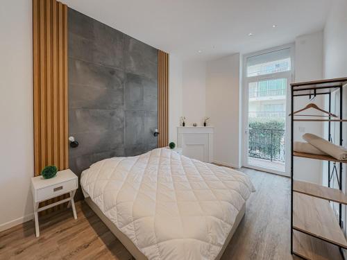 une chambre avec un grand lit et une grande fenêtre dans l'établissement Cozy Home Cannes, à Cannes