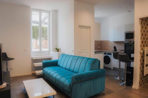 un salon avec un canapé bleu et une cuisine dans l'établissement Cozy Home Cannes, à Cannes