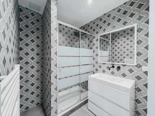 une salle de bain avec un lavabo blanc et un miroir dans l'établissement Cozy Home Cannes, à Cannes