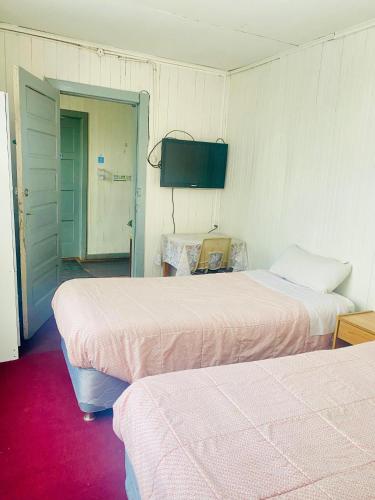 a room with two beds and a television in it at Hostal en Valdivia in Valdivia