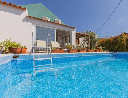 a villa with a swimming pool and a house at Casa Pinhão in Sesimbra