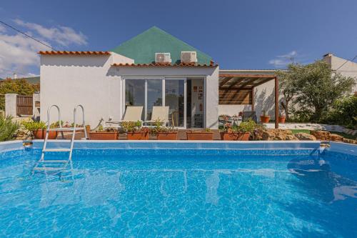 a swimming pool in front of a house at Casa Pinhão in Sesimbra