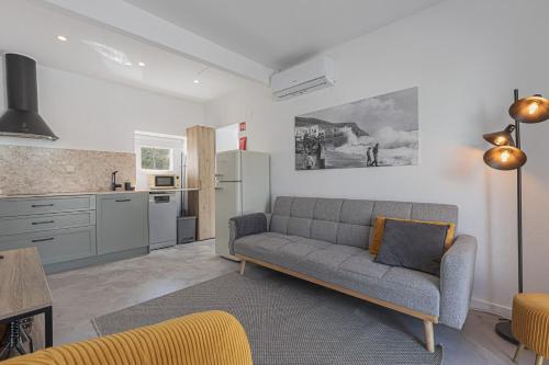 a living room with a couch and a kitchen at Casa Pinhão in Sesimbra