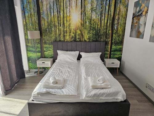 a bedroom with a bed with two towels on it at Central Urban Studio with Underground Parking in Târgu-Mureş