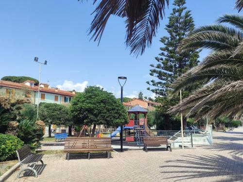 a park with benches and a playground with palm trees at Ca' Asseu in Riva Trigoso