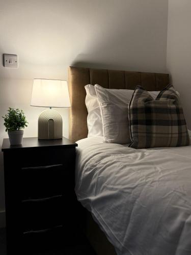una camera da letto con un letto con una lampada e una pianta di Spacious & Modern house in St Helens a Saint Helens