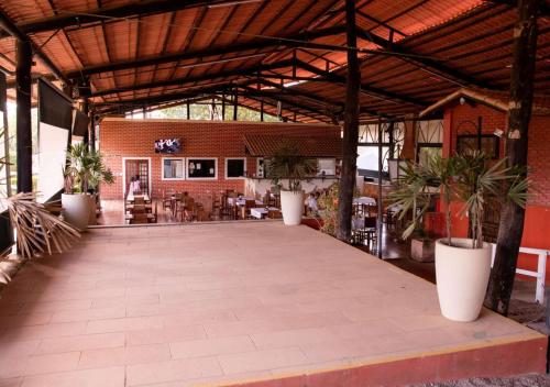 um grande pátio com plantas em vasos em um prédio em Chalé Mississippi - Camping Carrion - ITU em Itu