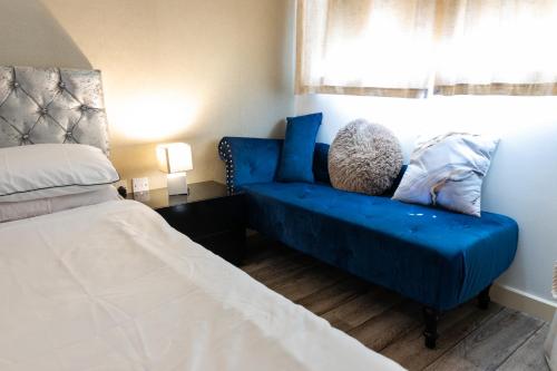 a bedroom with a blue couch next to a bed at FIve Star Rated Condo in Manchester