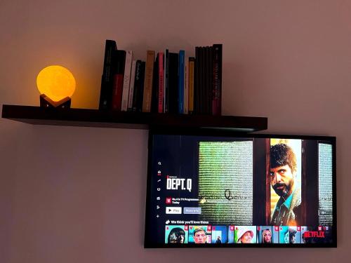 a tv sitting on a shelf with books at Gate 10 in Bari