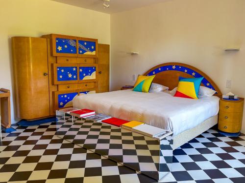 une chambre avec un lit et un sol à carreaux dans l'établissement La Galerie, maison de charme au coeur du Luberon, à Saint-Saturnin-lès-Apt