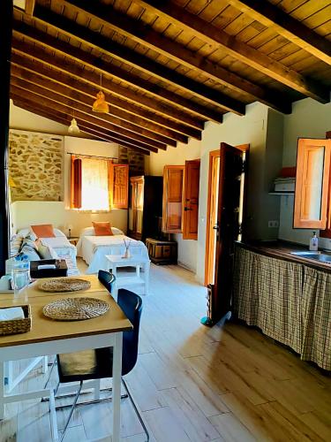 a living room with a table and a room with a bed at La Casa de Cadia I in El Real de San Vicente