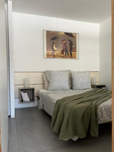 une chambre avec un lit et un tableau au mur dans l'établissement Grand studio vue sur la piscine, à Montferrier-sur-Lez