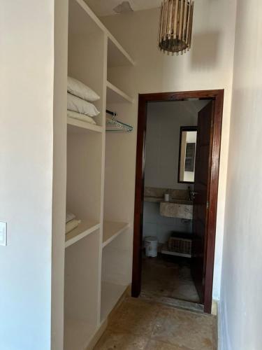 een kamer met een kast met planken en een spiegel bij SWEET HOME Águas Belas in Águas Belas