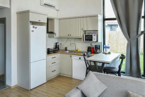 Una cocina con un refrigerador blanco y una mesa. en New Balturk Nature Villas, en Sapanca
