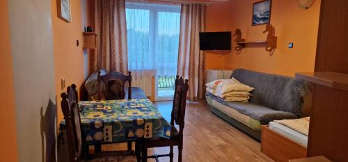 a living room with a couch and a table and chairs at Róża Wiatrów 2 Władysławowo in Władysławowo