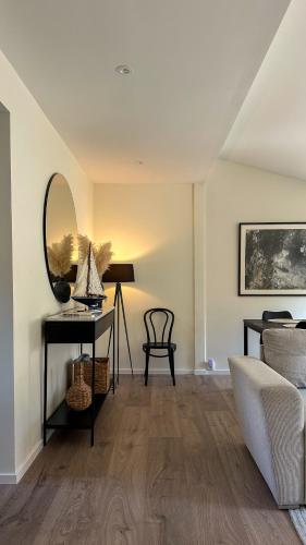 a living room with a table and a mirror at Strandviks semesterboende in Halmstad