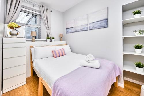 ein kleines Schlafzimmer mit einem Bett und Regalen in der Unterkunft Princess Blue 2 ~ Portrush by the Sea in Portrush