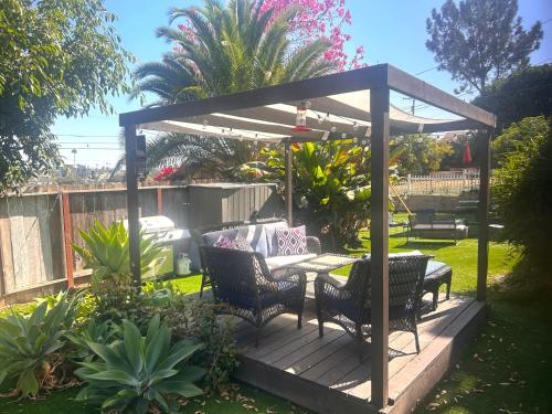 a pergola with a table and chairs on a deck at Casa California - Backyard, BBQ, Firepit & Near Beaches in San Diego