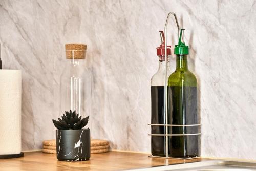 zwei Flaschen Wein auf einem Tisch mit einem Kaktus in der Unterkunft Princess Blue 2 ~ Portrush by the Sea in Portrush