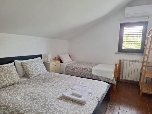 a bedroom with two beds and a window at Cantinho do Mel in Castro Daire
