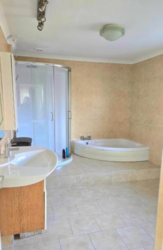 a bathroom with a tub and a sink at Luxury Seaview Escape - Mumbles in Oystermouth